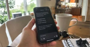 Hand holding a smartphone showing an AI assistant listing three business suggestions in a chat